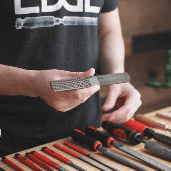 a guitar neck with hand tools